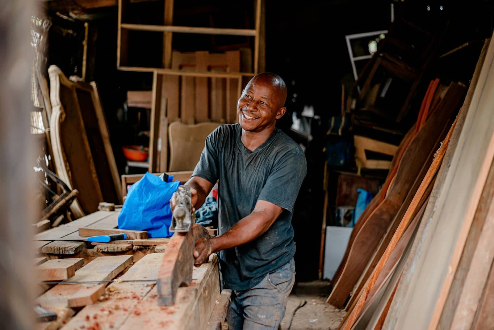 Un menuisier souriant au travail dans son atelier